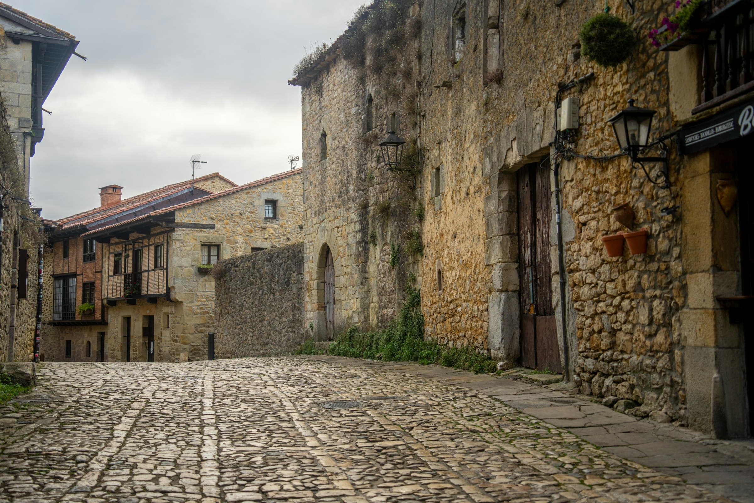 Narrow cobblestone street lined with rustic old stone buildings in a European town