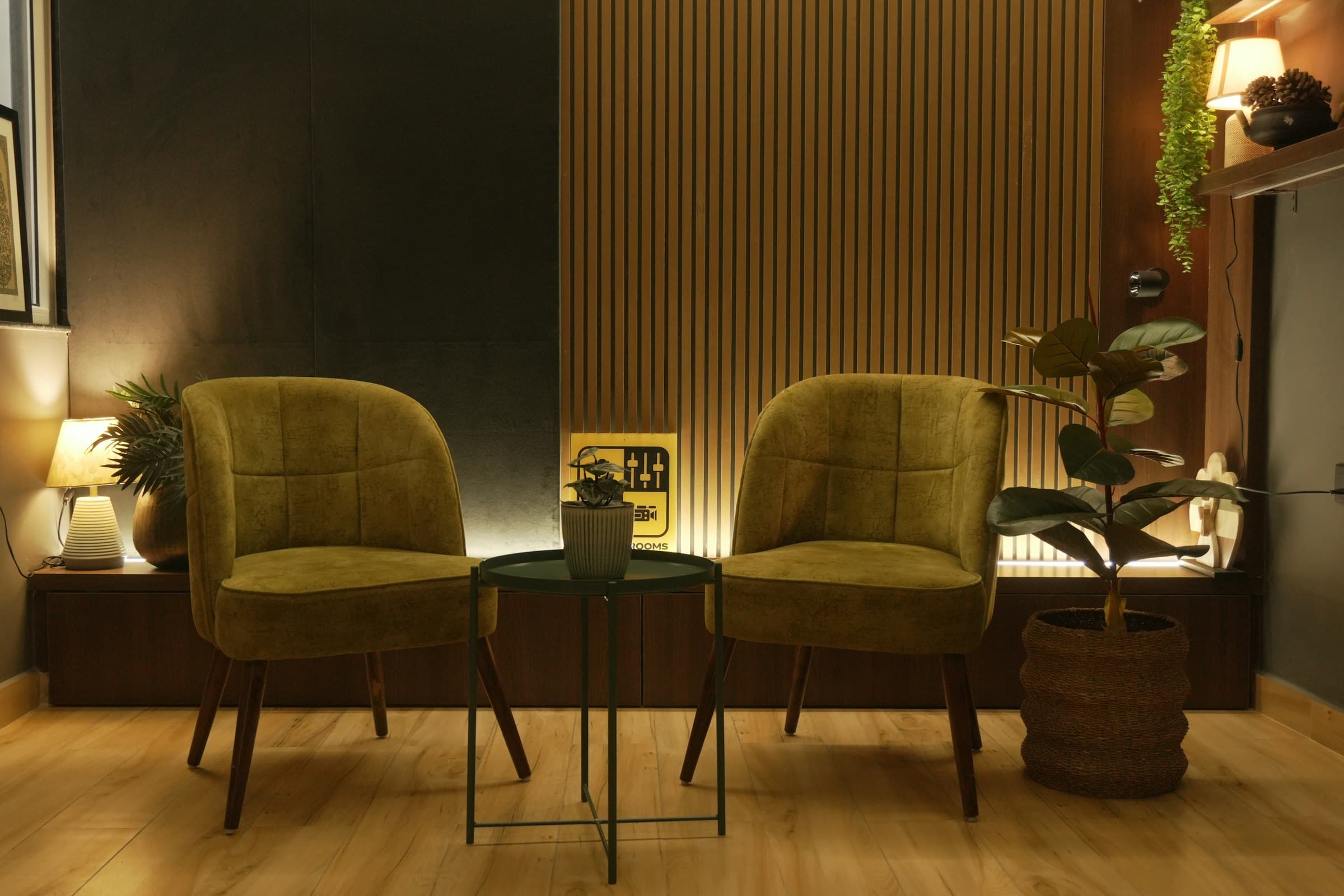 A cozy, stylishly furnished boutique hotel lounge with green velvet chairs