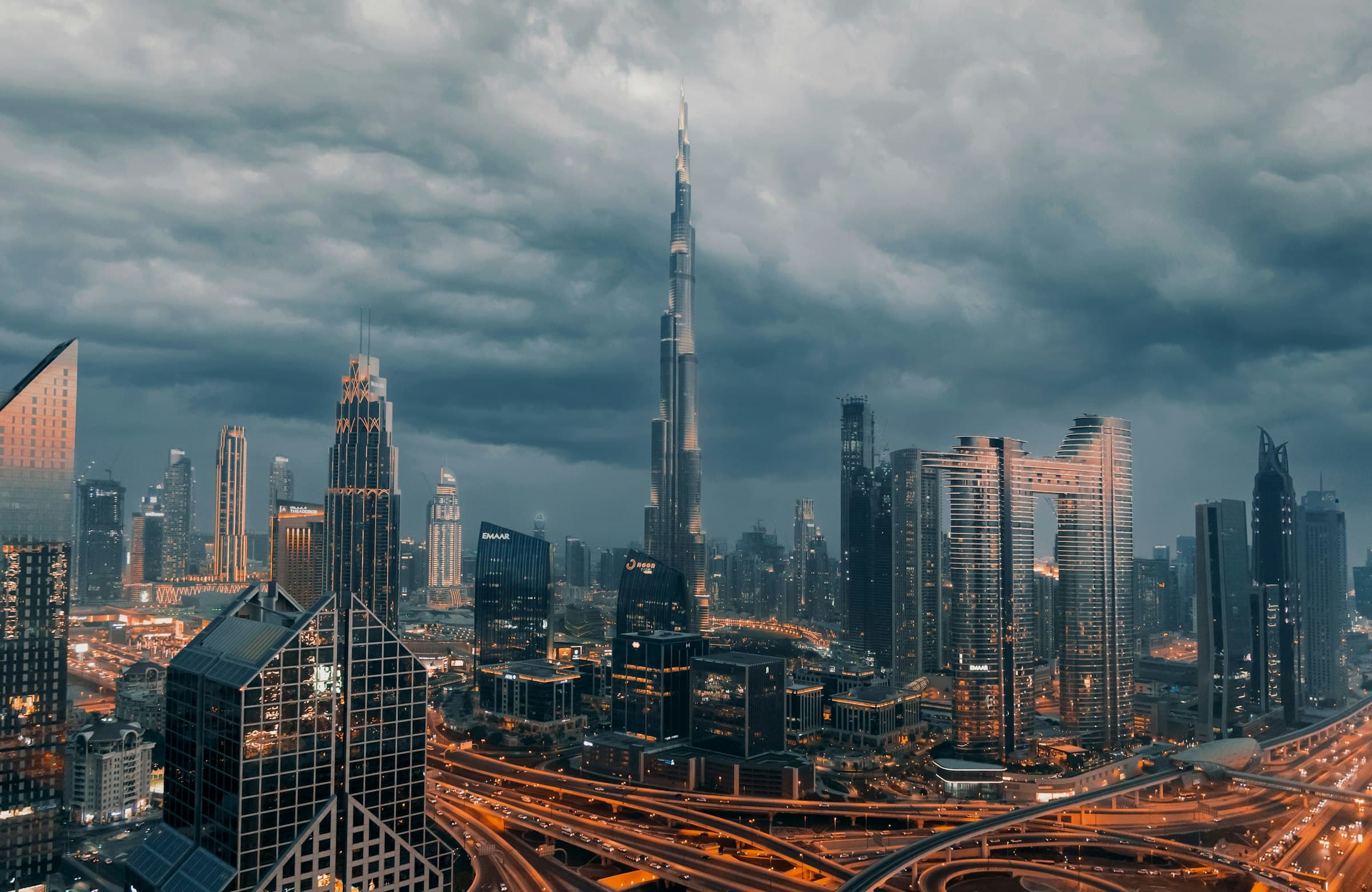 The Burj Khalifa rising above the Downtown Dubai skyline under dramatic skies
