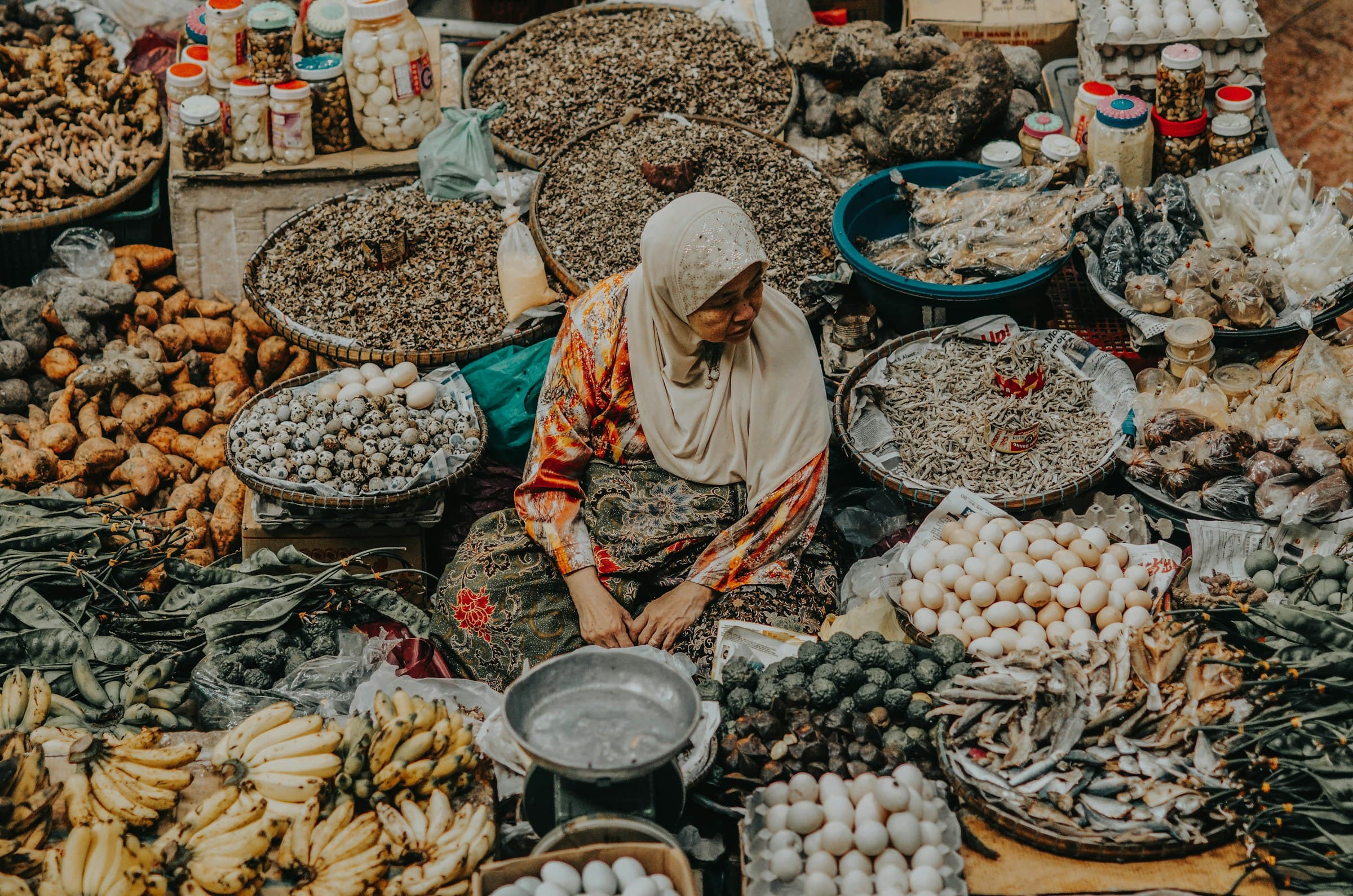 A woman selling fresh produce at a local outdoor market